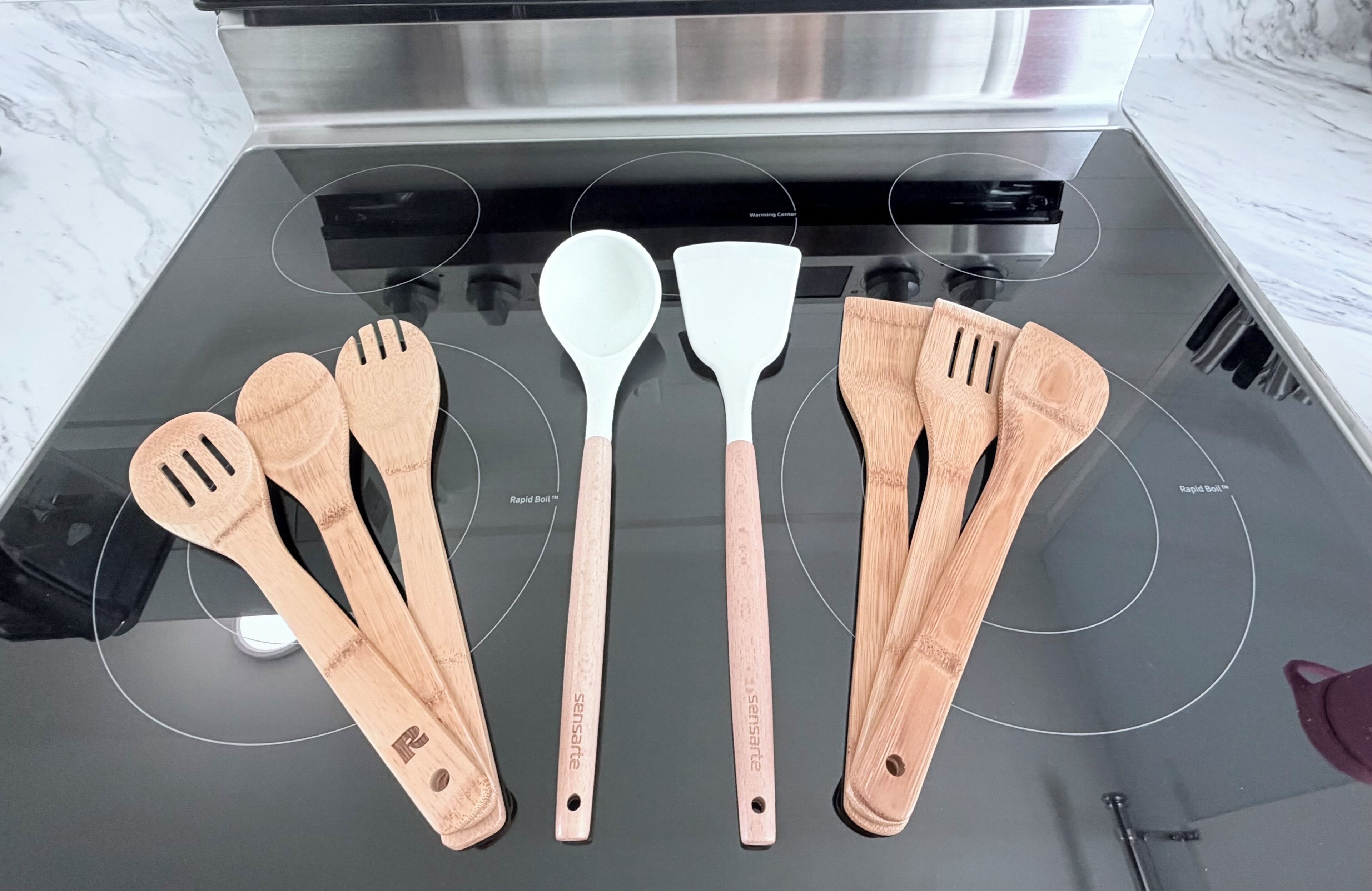 Een keuken met een roestvrijstalen afzuigkap boven een zwart fornuis.