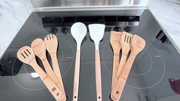 Een keuken met een roestvrijstalen afzuigkap boven een zwart fornuis.