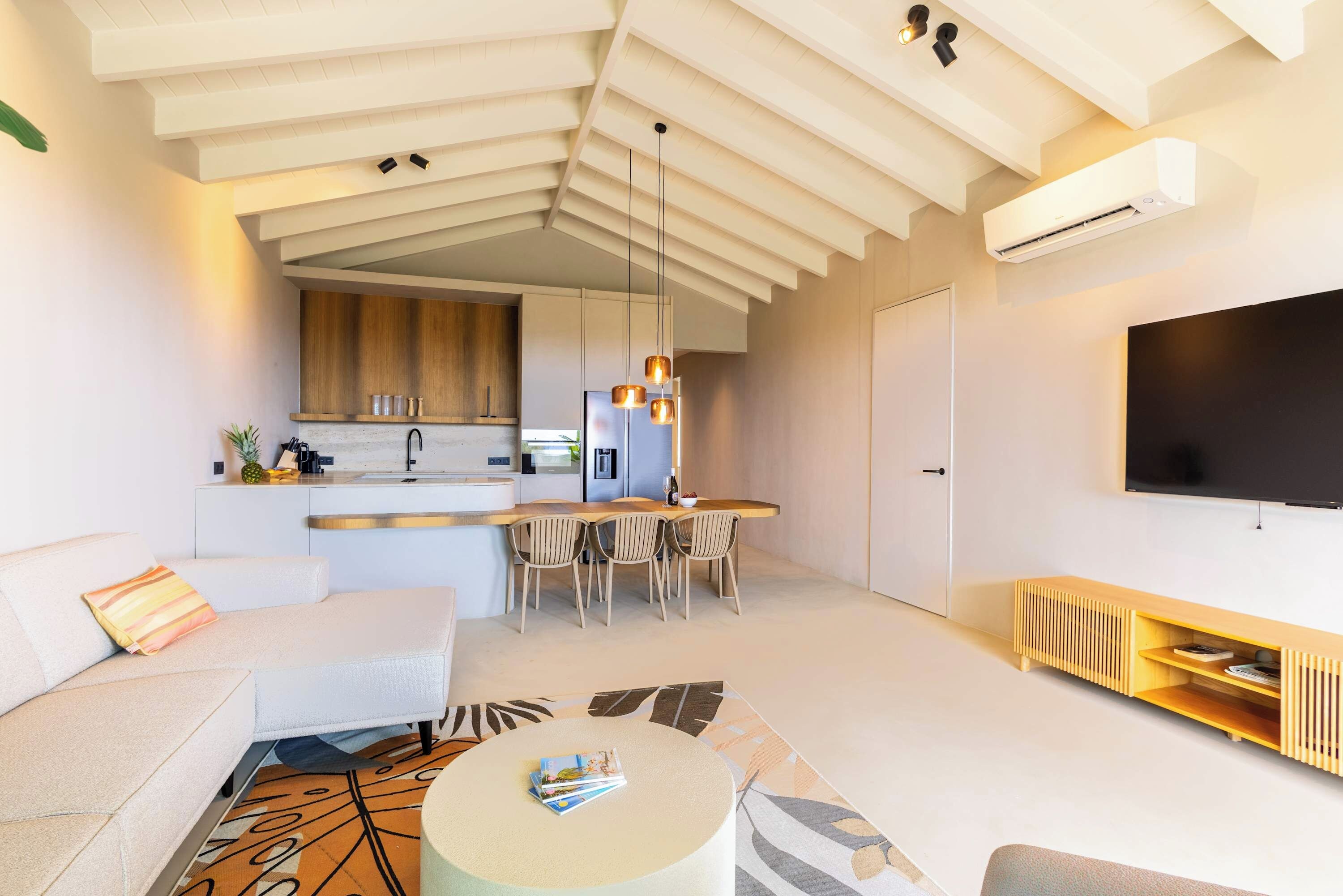 A modern living space with a kitchen, dining area, and a seating area with a coffee table.