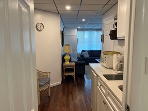 A compact living space with a kitchenette, a dining area, and a seating area with a sofa and a lamp. - Lovely 1-bedroom condo with pool in lovely Wildwood right by beach and boardwalk (Wildwood)