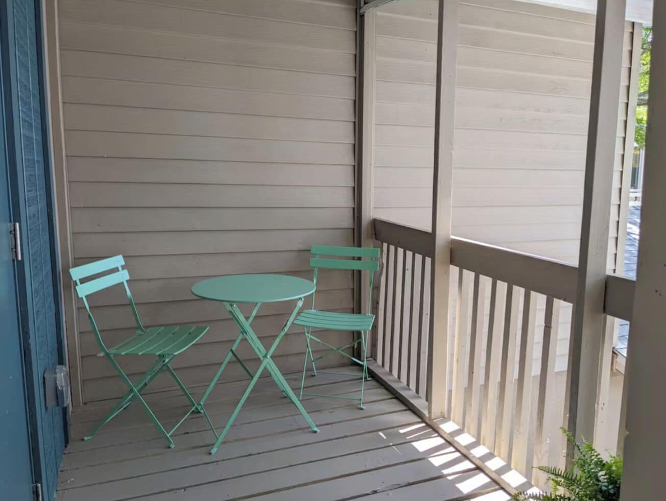 A covered outdoor seating area with a table and two chairs.