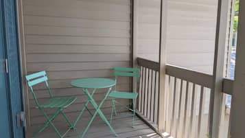 A covered outdoor seating area with a table and two chairs.