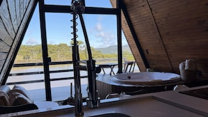 A kitchen with a sink, a window, and a view of the outdoors. - Lake cabin with hot tub and mountain views (Bom Jardim da Serra)