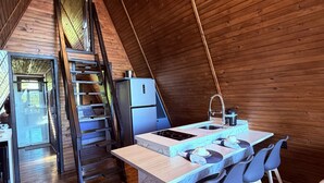 Una cocina acogedora con encimera de mármol, un lavamanos y sillas azules.