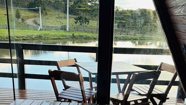Un jacuzzi con vista a una terraza de madera y una masa de agua.