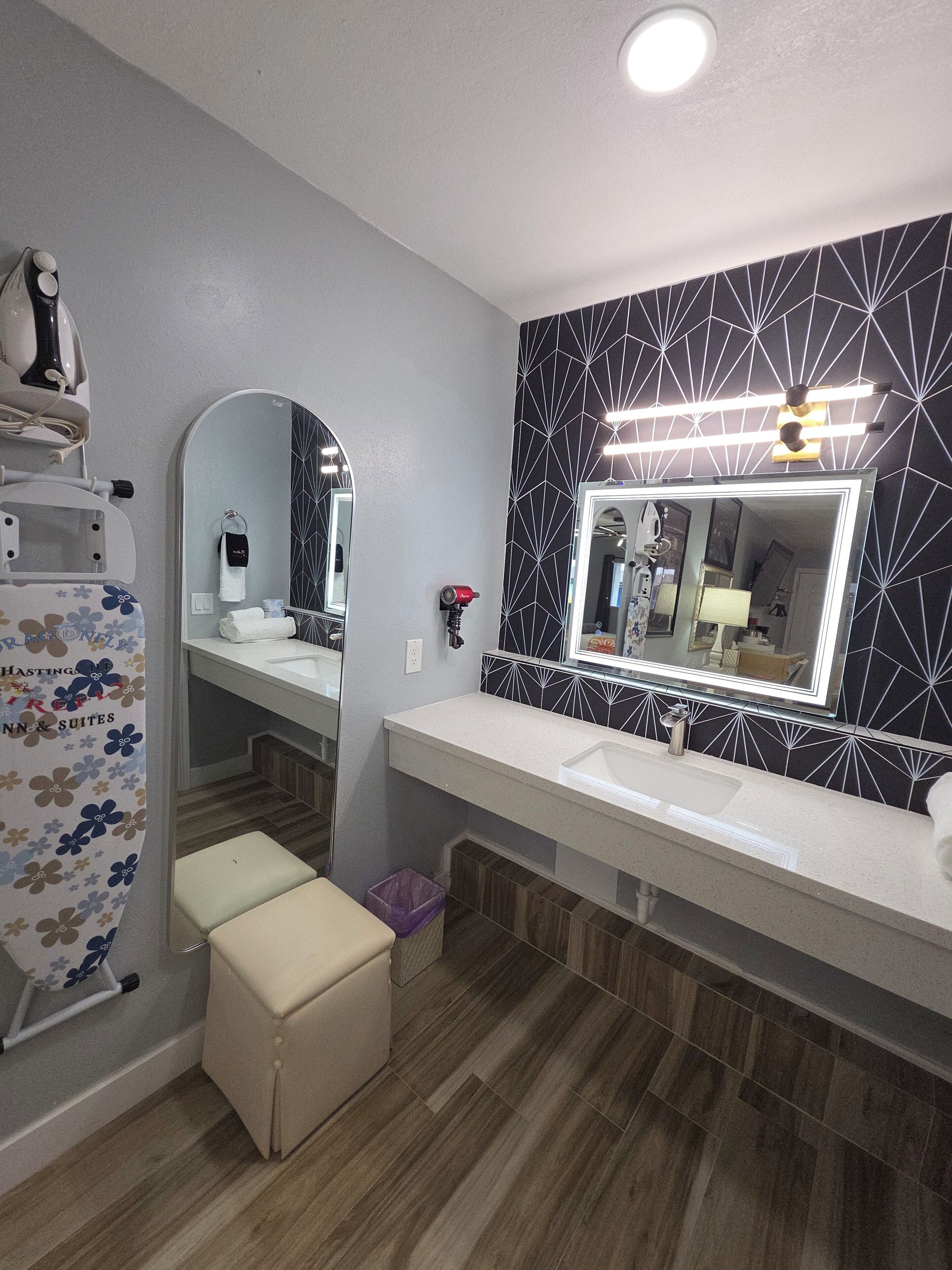 A modern bathroom with a vanity, a large mirror, and a shower area.