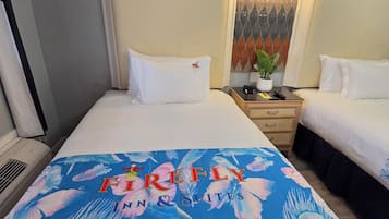 A hotel room with two beds, a nightstand, a lamp, and a decorative wall panel.