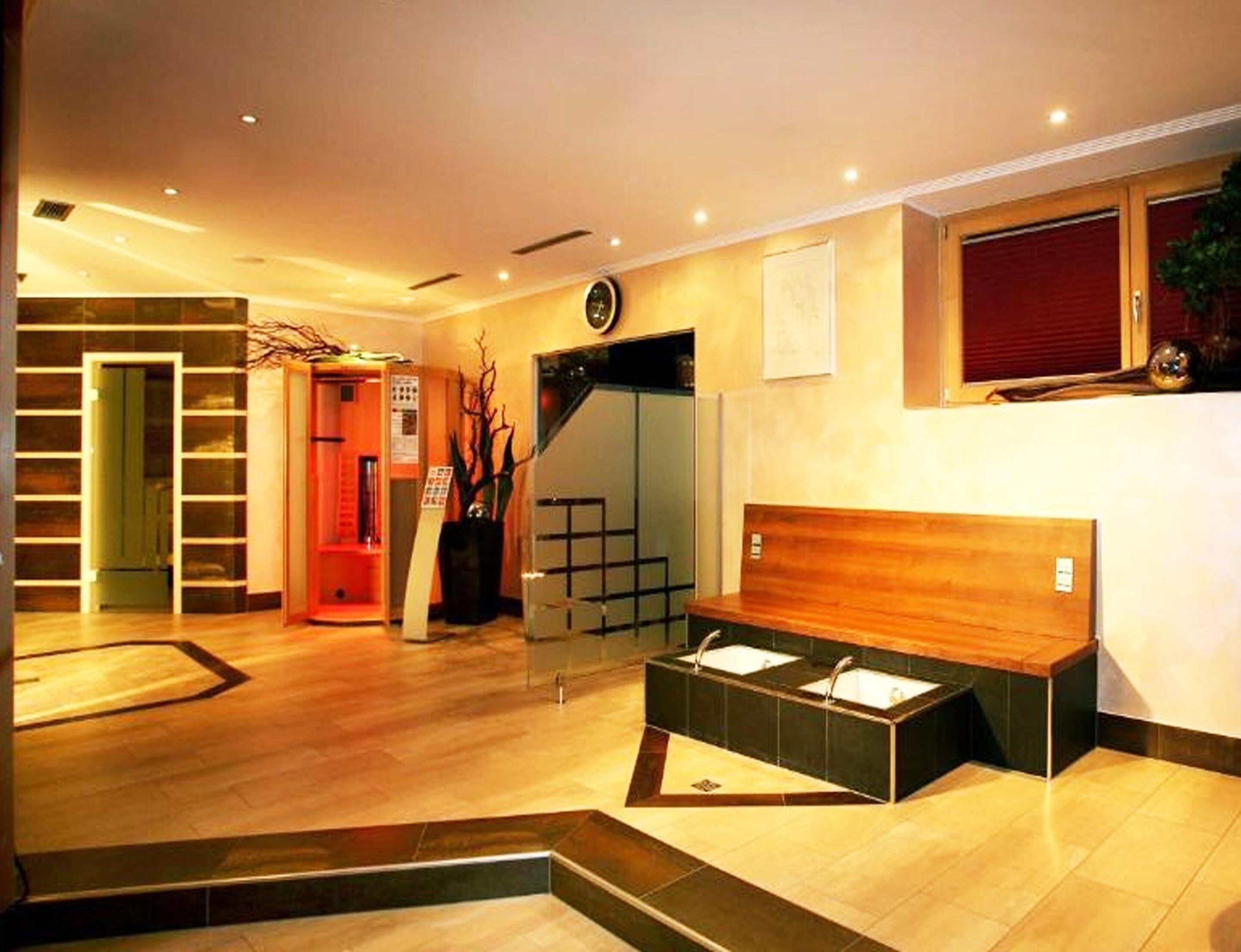 Eine Hotelhalle mit einer Rezeption, einer Treppe und einer Sitzecke.