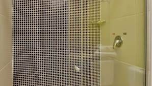 Un baño moderno con cabina de ducha de vidrio, una bañera blanca y pared de ducha con azulejos.