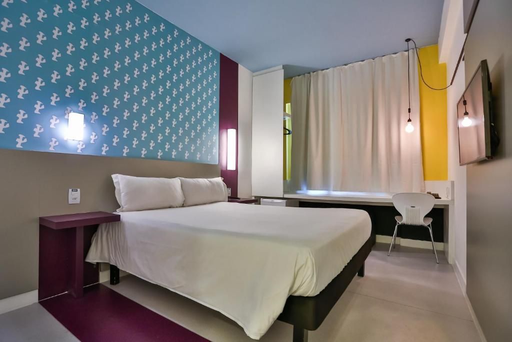 Quarto com cama, escrivaninha e cadeira.