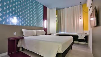 Quarto com cama, escrivaninha e cadeira.