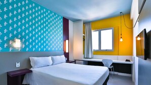 Una habitación de hotel moderna con una cama, un escritorio y una silla.