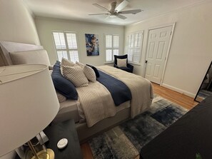 A bedroom with a bed, a chair, a lamp, a ceiling fan, and a door. - Beautiful  3-bedroom 2 bath house near NRG Stadium, Rodeo and Medical center (Houston)