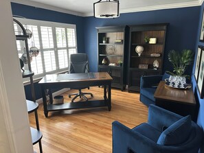 A room with a desk, office chair, and a blue sofa. There is a bookshelf with decorative items and a globe. - Beautiful  3-bedroom 2 bath house near NRG Stadium, Rodeo and Medical center (Houston)
