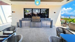 Eine Terrassengaststätte mit Grillplatz, Sitzgelegenheiten und Blick auf die Stadtlandschaft.