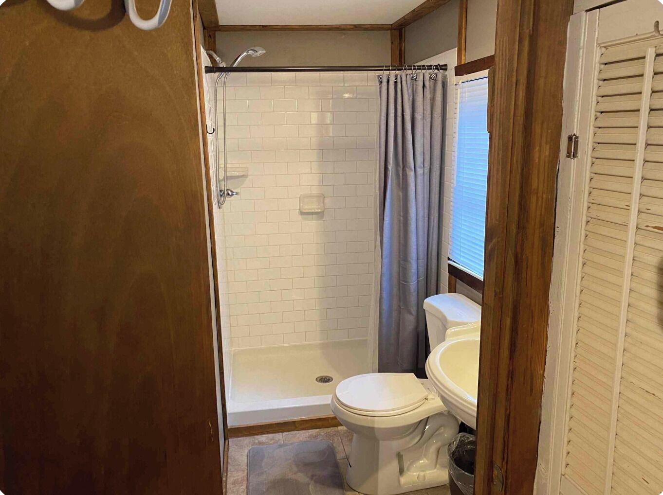 A bathroom with a shower, toilet, and sink.