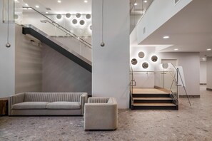 Ein modernes Interieur mit einer Treppe, einem Sofa und einem kleinen Hocker.
