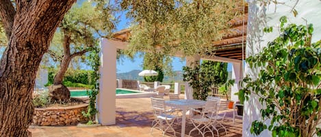 Un patio con piscina, mobiliario exterior y vistas al paisaje.