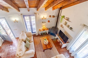 Ein gemütliches Wohnzimmer mit einer Couch, einem Couchtisch, einem Kamin und einem Fernseher.