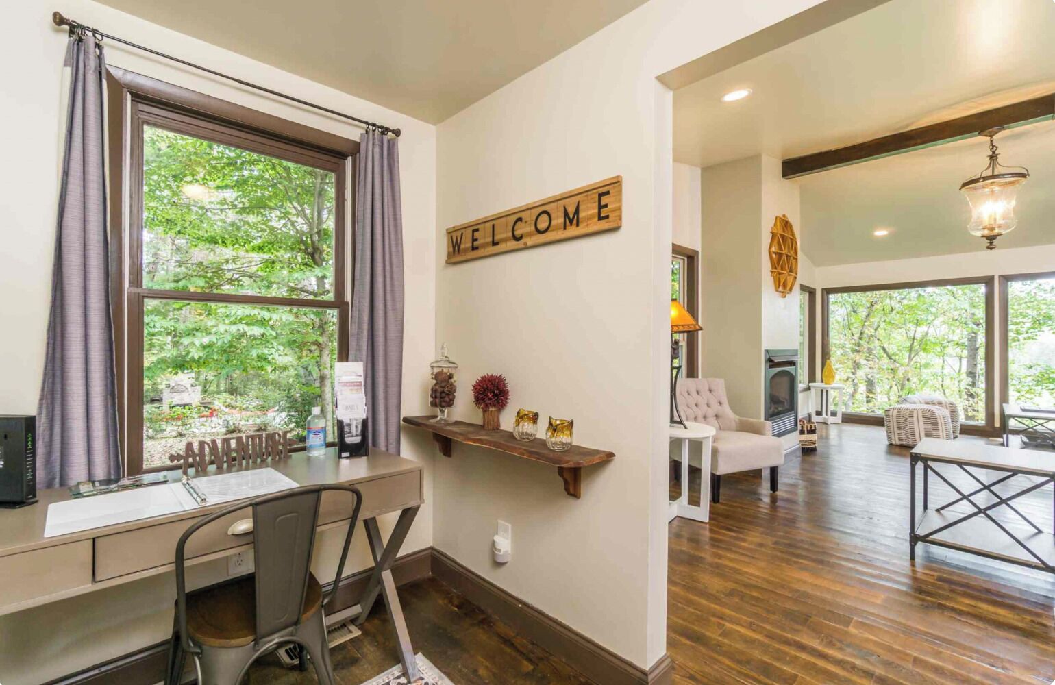 A modern interior with a desk, chair, and a 'WELCOME' sign on the wall.