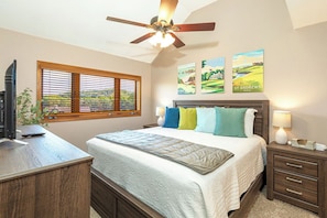 A bedroom with a bed, a desk, a ceiling fan, a window with blinds, and wall art. - Perfect Fall Getaway: charming 1-bedroom townhome in Galena on golf course (Galena)