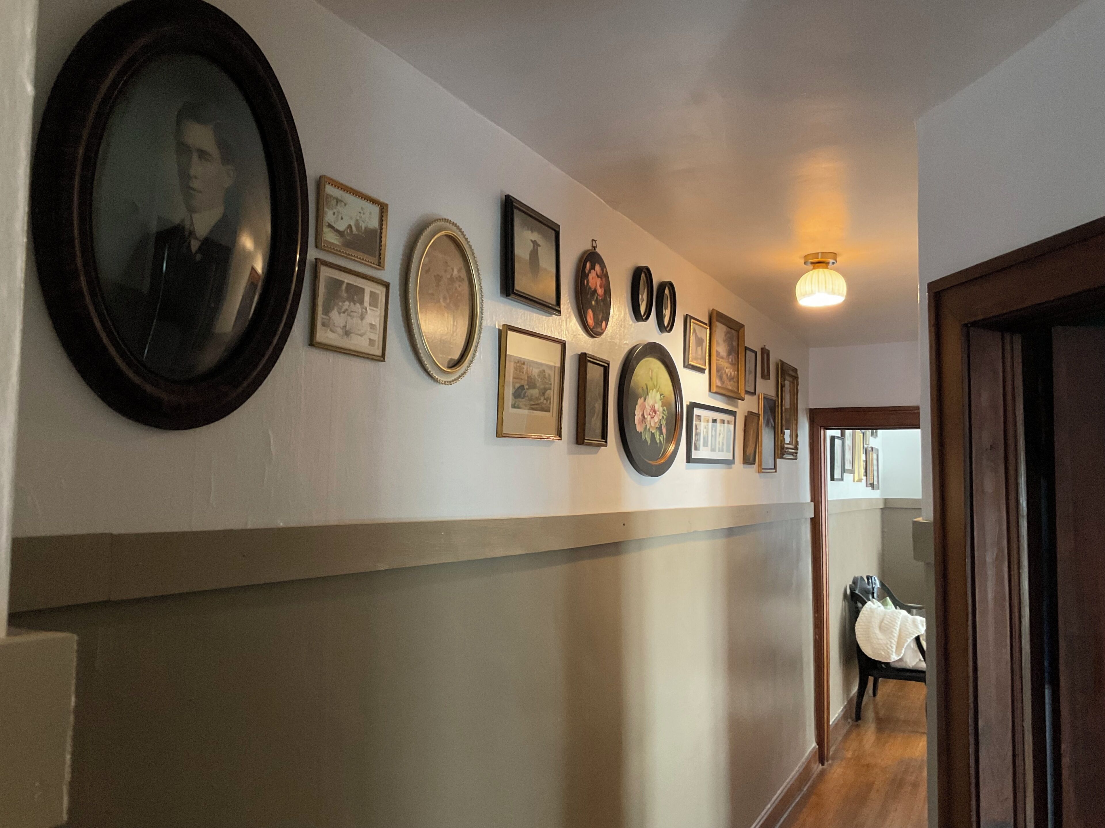 A hallway with a row of framed pictures on the wall.