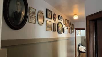A hallway with a row of framed pictures on the wall.