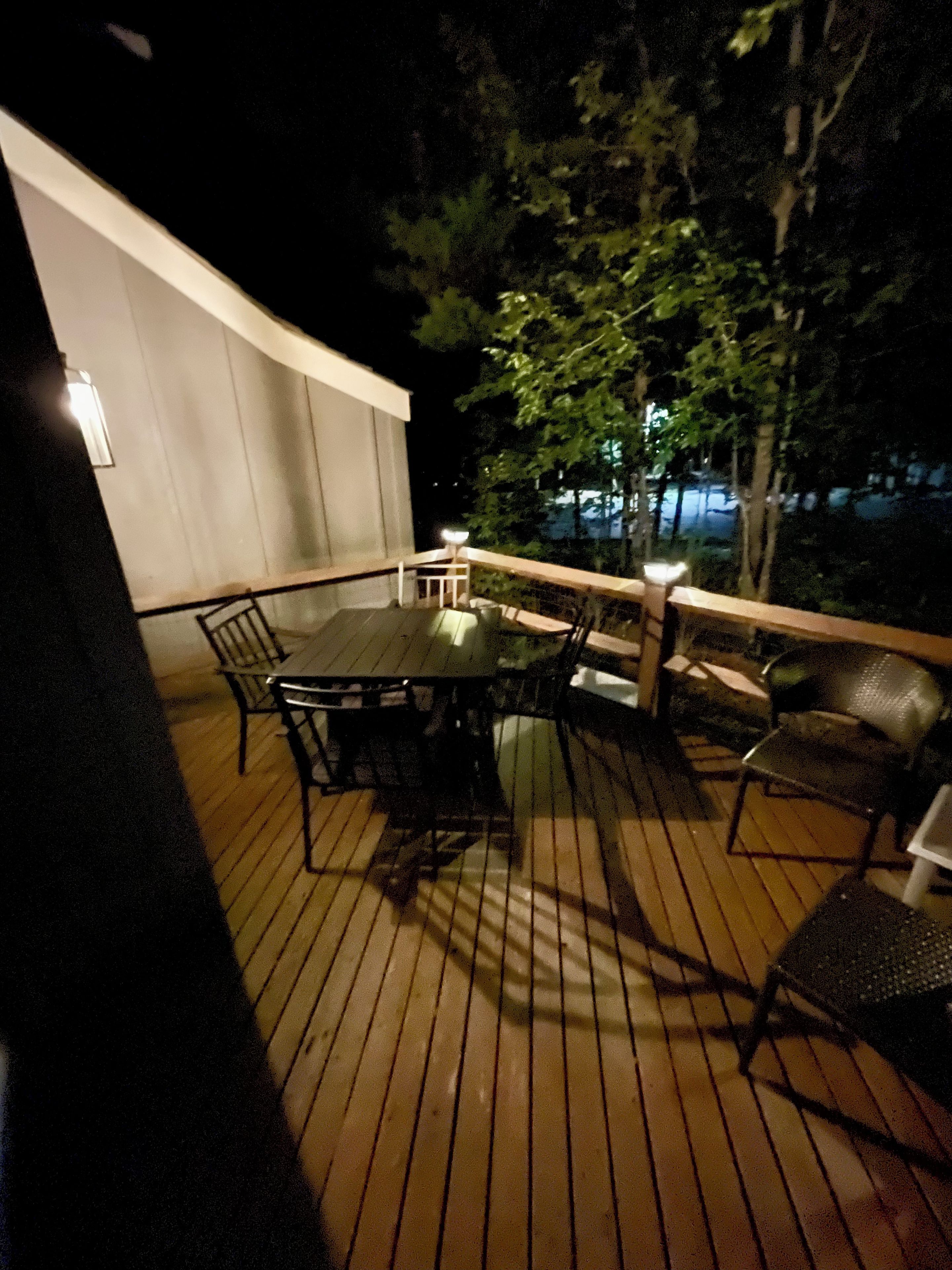 Eine Terrasse im Freien mit Tisch und Stühlen, umgeben von einem Geländer.