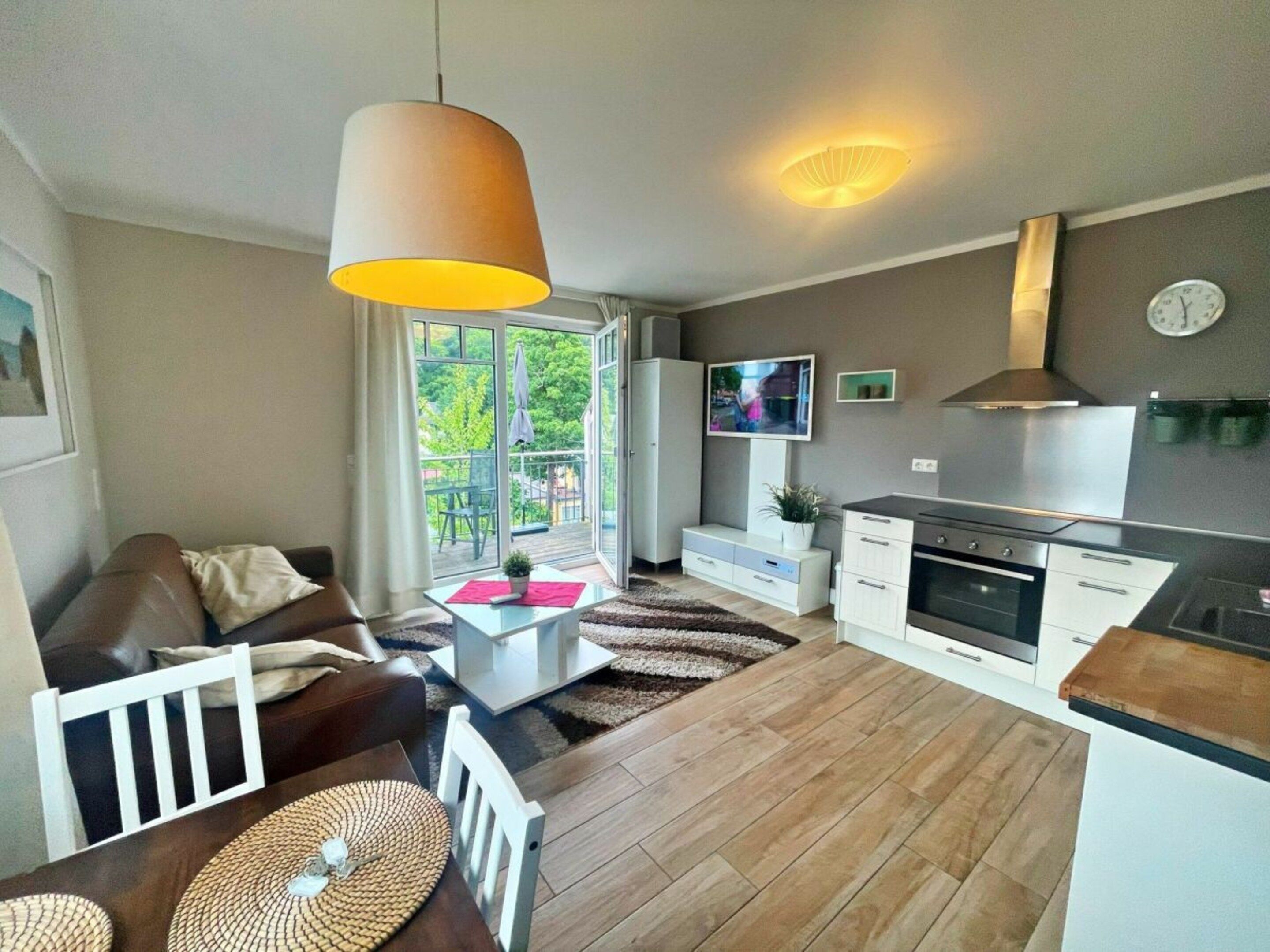 A modern living room with a sofa, coffee table, and a dining area.