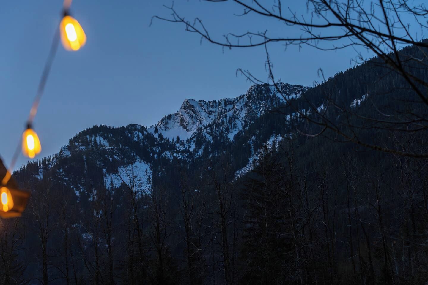 Eine Berglandschaft mit schneebedeckten Gipfeln und bewaldetem Gebiet.
