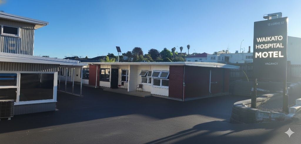 A building with a sign reading 'WAIKATO HOSPITAL MOTEL' and a vacant sign indicating no rooms available.