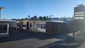 Un edificio con un letrero que dice 'WAIKATO HOSPITAL MOTEL' y un aviso de 'no hay habitaciones disponibles'.