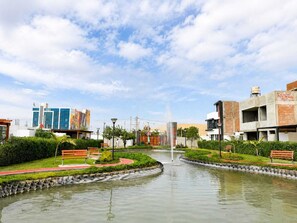 A landscaped area with a fountain, benches, and a water feature.