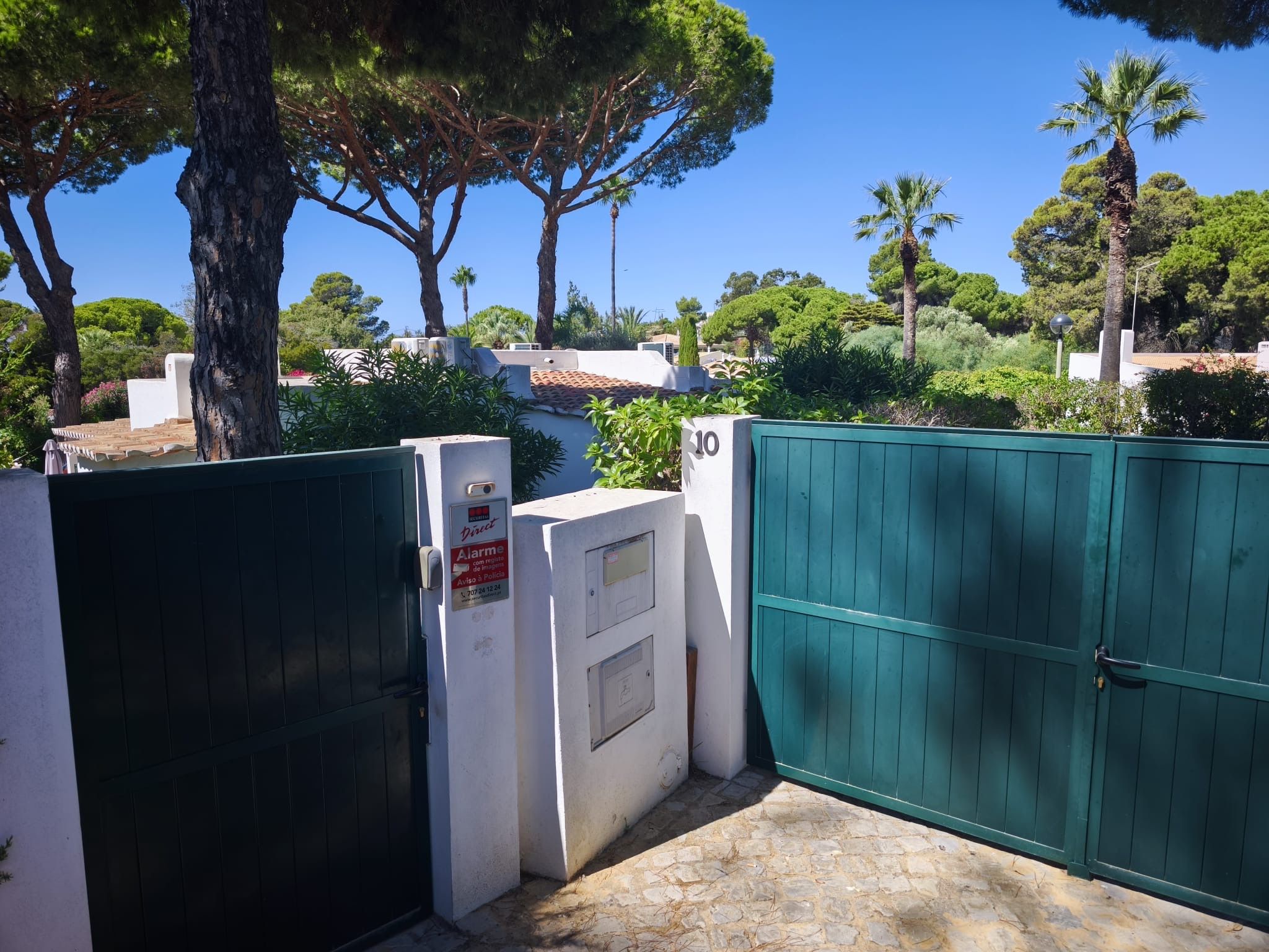 A gated entrance with a security panel and a number sign indicating the location.
