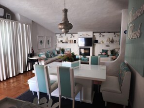 Ein modernes Wohnzimmer mit Essbereich, Fernseher und Kamin.