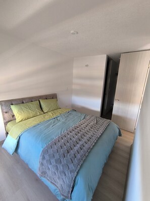 Ein Schlafzimmer mit einem Bett, einem Kleiderschrank und einer Tür.