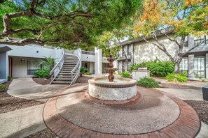 A courtyard with a central fountain, a staircase, and surrounding greenery. - The perfect gem in the heart of Phoenix Biltmore! (Phoenix)