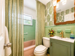 A bathroom with a bathtub, toilet, and sink. - Vrbo Property (Treasure Island)