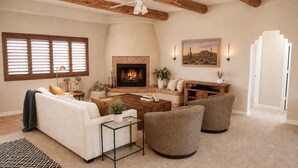 A living room with a fireplace, a sofa, a coffee table, and a TV stand.