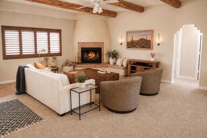 A living room with a fireplace, a sofa, a coffee table, and a TV stand.