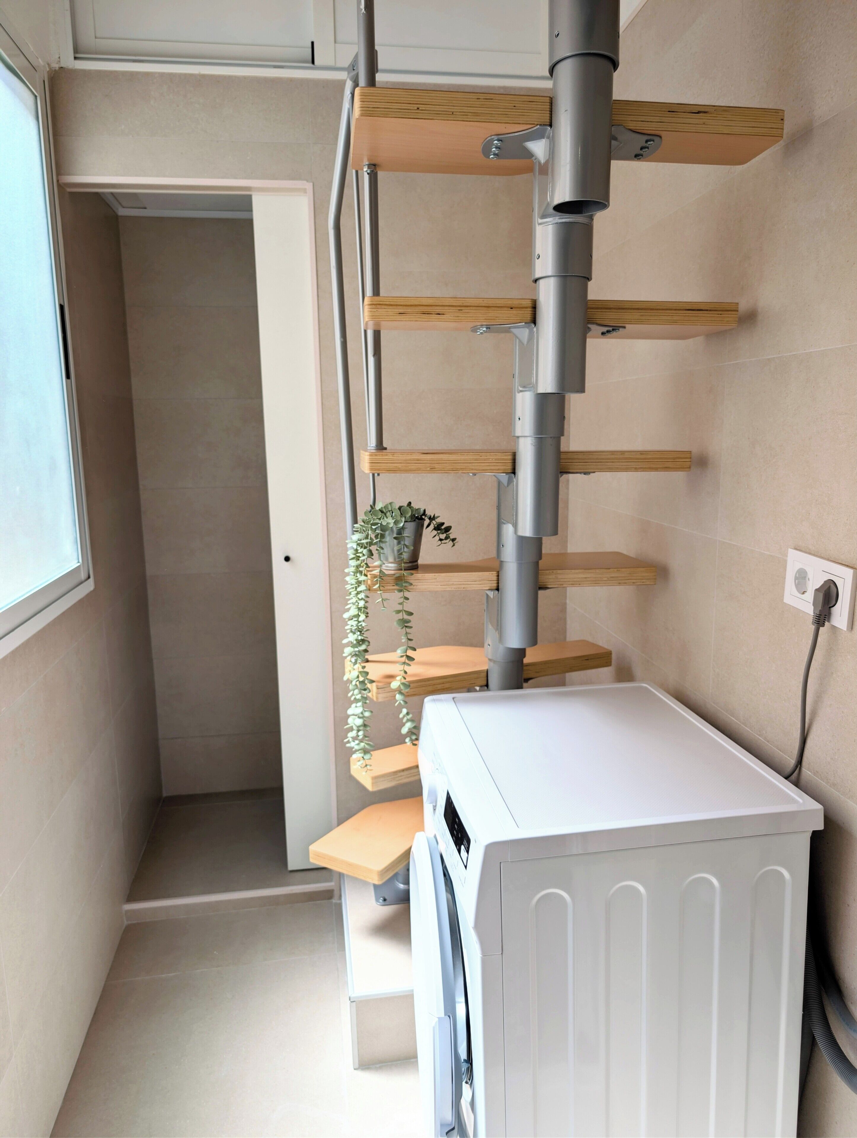Una habitación compacta con un radiador blanco, estantes de madera y una planta en maceta.