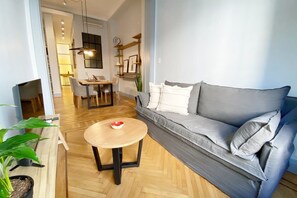 A modern living room with a grey sofa, a round wooden coffee table, and a dining area with a table and chairs. - 10- Incredible Apt. Privileged Location Recoleta (Buenos Aires)