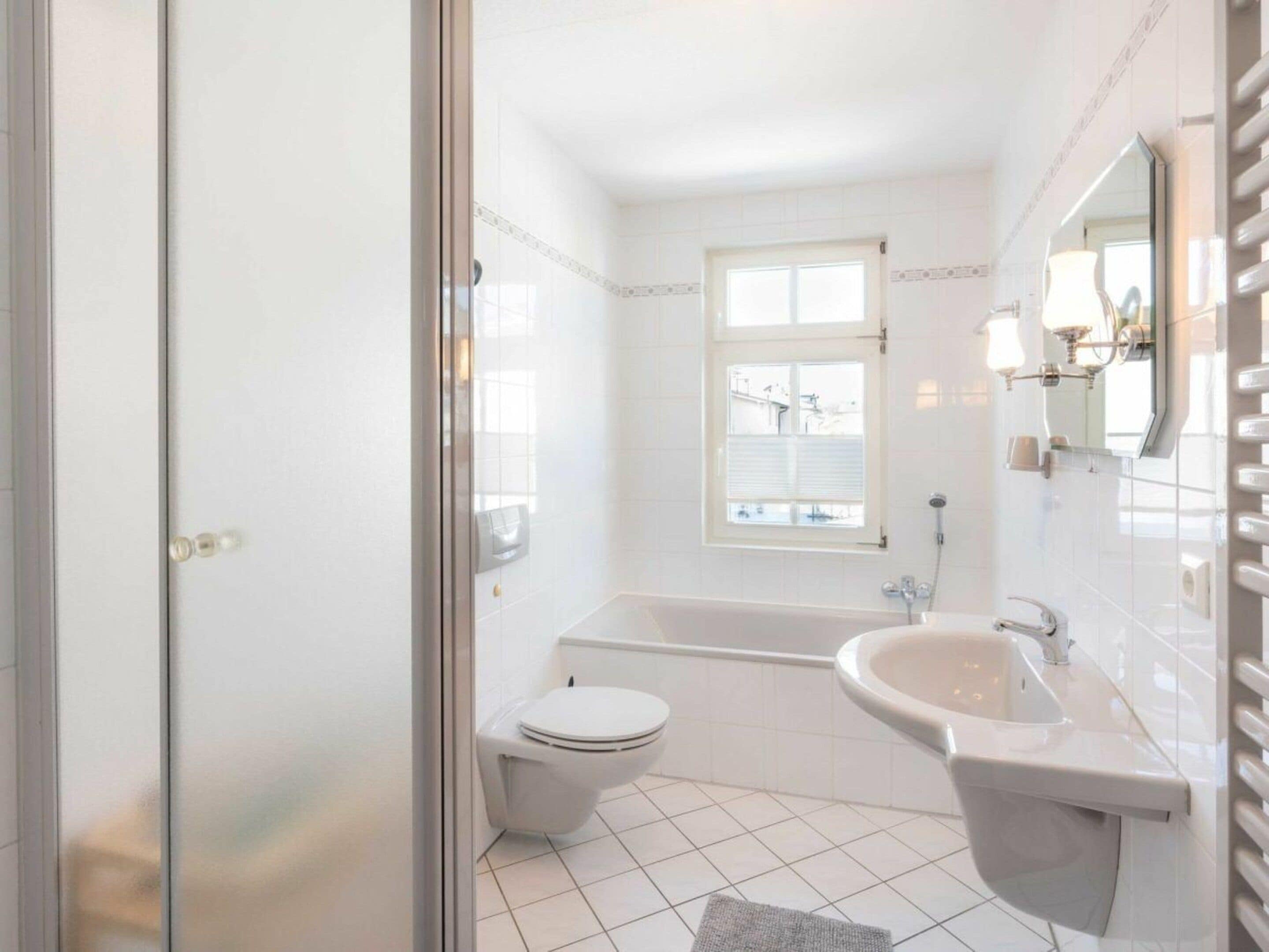 A bathroom with a toilet, bathtub, and sink.