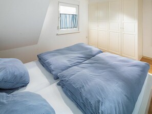 A bedroom with a single bed, a window with curtains, and a wardrobe. - Mariechen am Meer Apt. 2 - Norddeich (Norden)