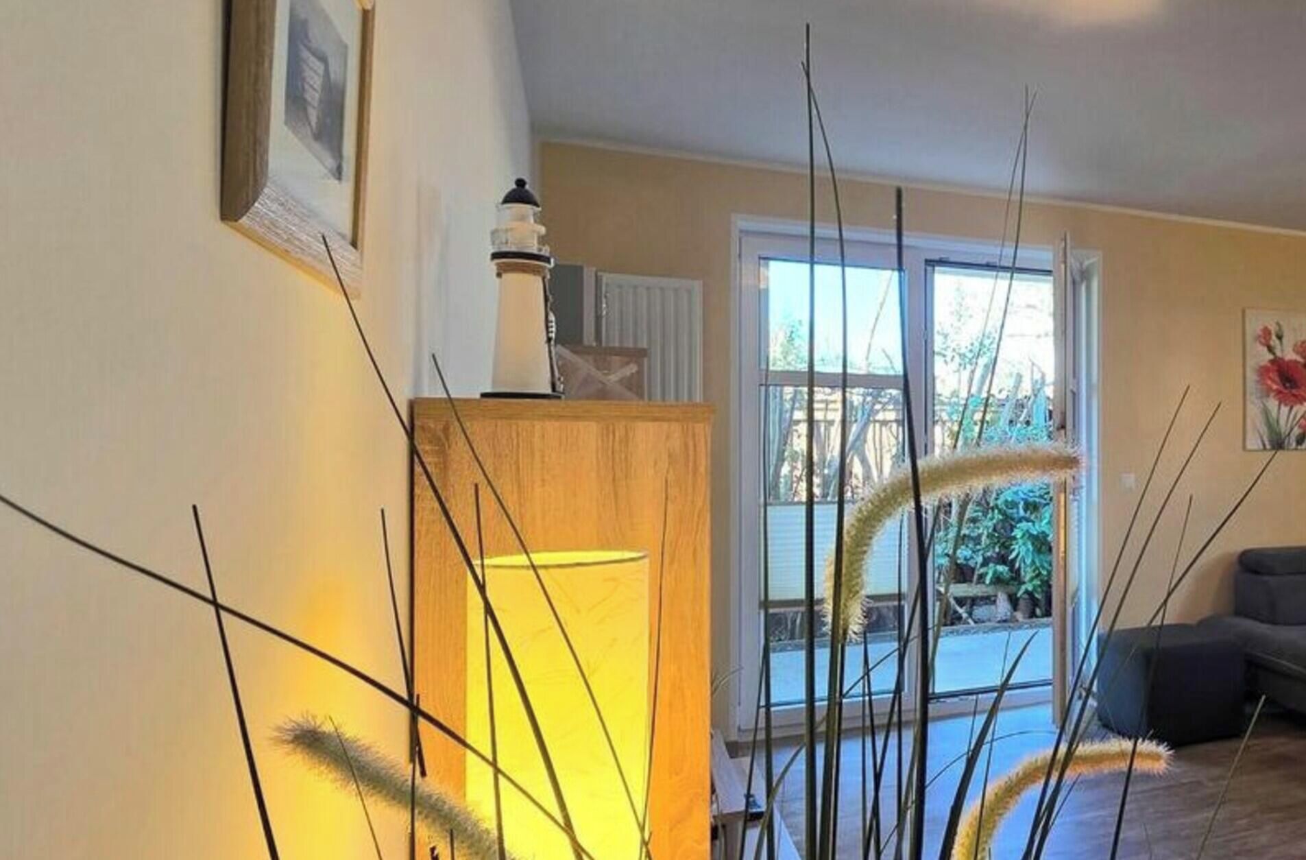 Une pièce avec un meuble en bois, un tableau encadré et une fenêtre donnant sur un paysage verdoyant.