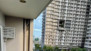 Ein Balkon mit Blick auf einen Basketballplatz und hohe Gebäude.