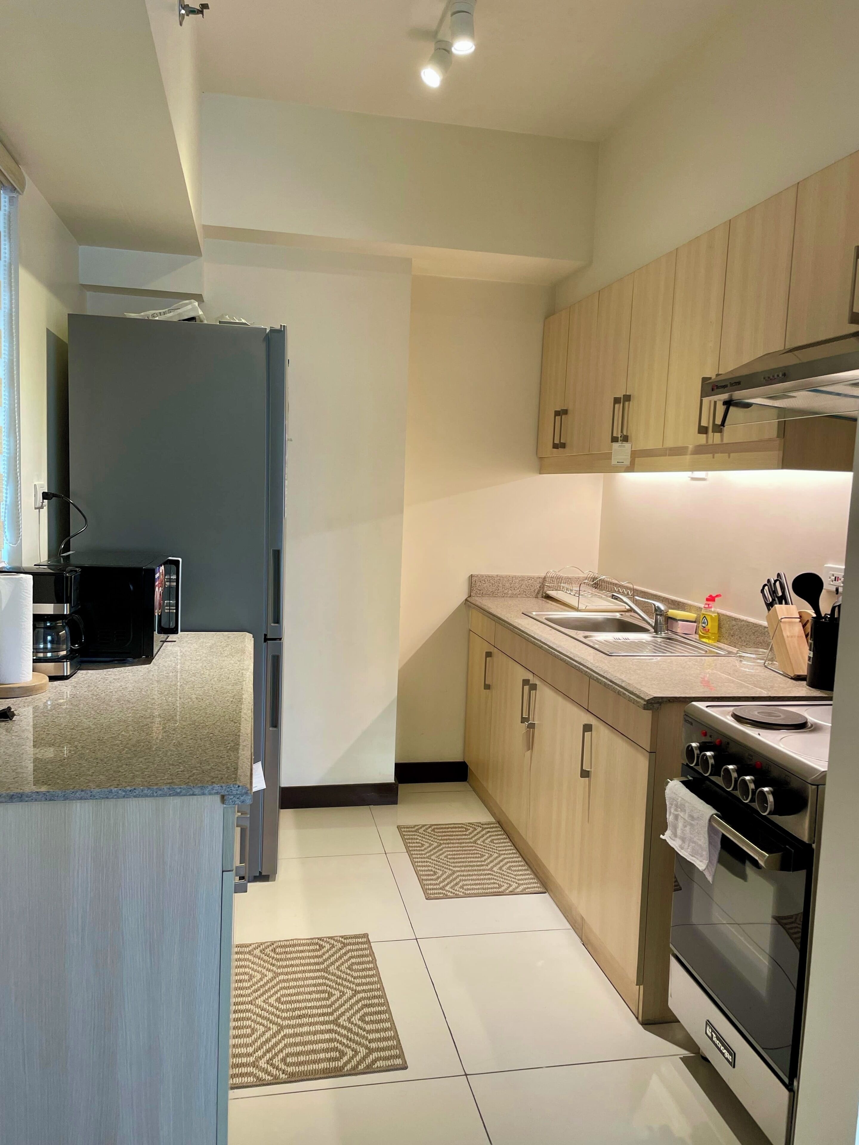 Een moderne keuken met een ingebouwde oven, magnetron en spoelbak.