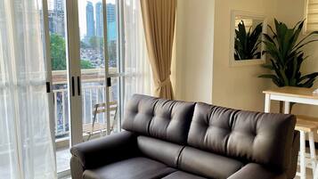 A modern living room with a leather sofa, a small wooden table, and a remote control on it.