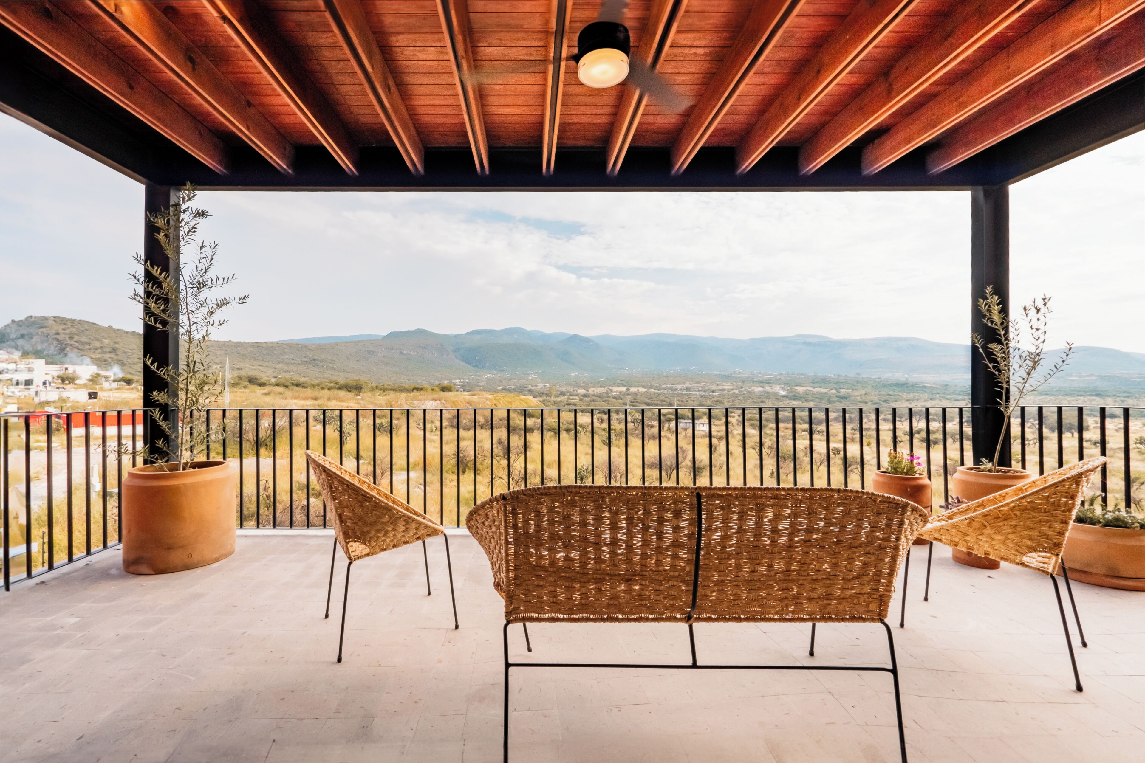 A covered outdoor seating area with a view of distant mountains.