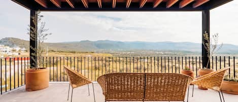 A covered outdoor seating area with a view of distant mountains.